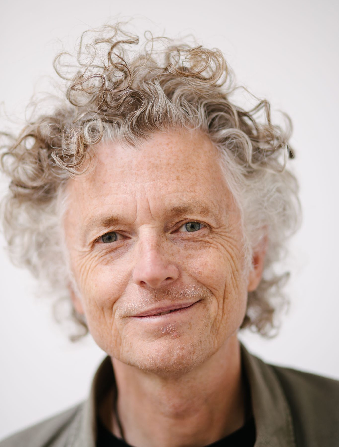 Headshot of Billy: a tall, slim, white man in his fifties with curly hair.